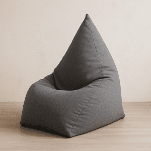 פוף שפיץ אפור בצורת קונוס מונח על רצפת עץ בהירה בחדר מודרני מינימליסטי.